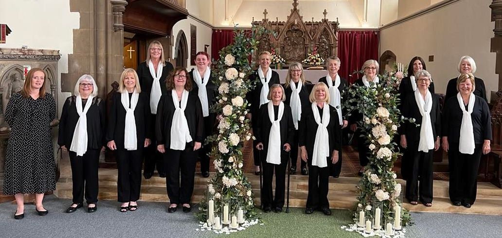 The choir at the front of a church with some floral decorations